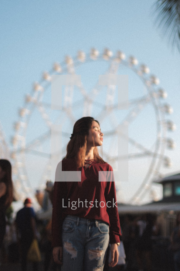 woman with a ferris wheel in the background 