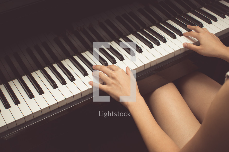 teen girl playing a piano 