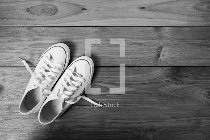 white sneakers on a wooden floor 