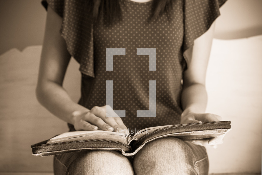 a teen girl reading a Bible in her lap 