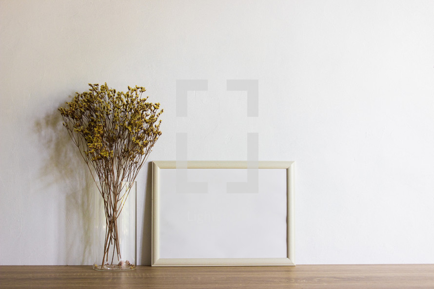 tall grasses in a vase and blank frame 