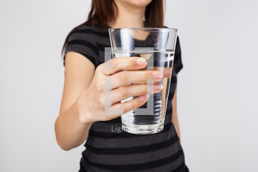 a woman holding a glass of water 