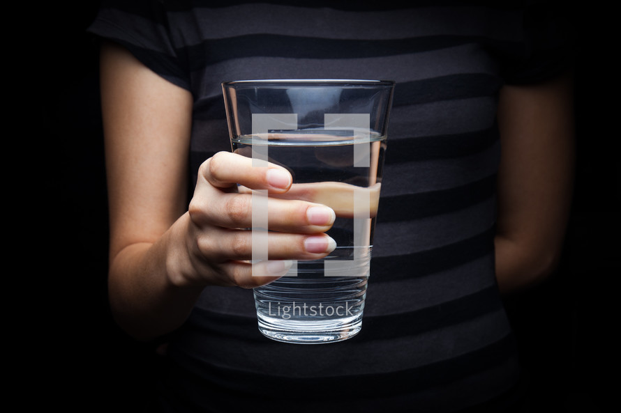 a woman holding a glass of water 