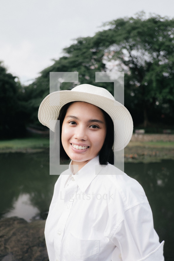 face of a smiling young woman in a hat 