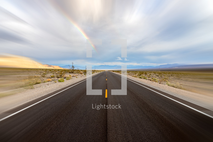 Desolate road with rainbow and motion blur