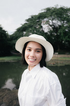 face of a smiling young woman in a hat 