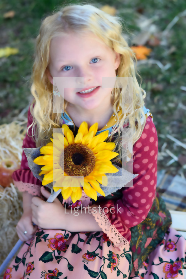young girl holding a sunflower 