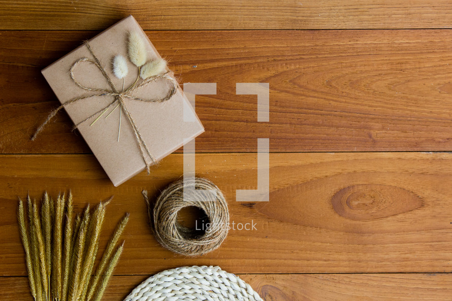 wrapped brown paper gift box and fuzzy grasses
