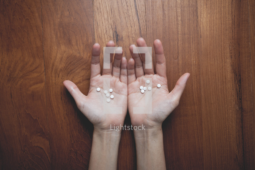 cupped hands holding pills 