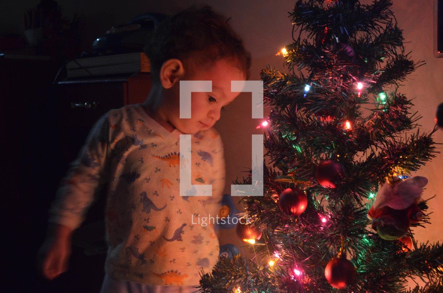 Child next to Christmas Tree