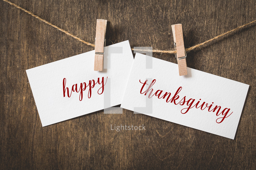 word happy thanksgiving on white card stock hanging from a clothespin on a clothesline 