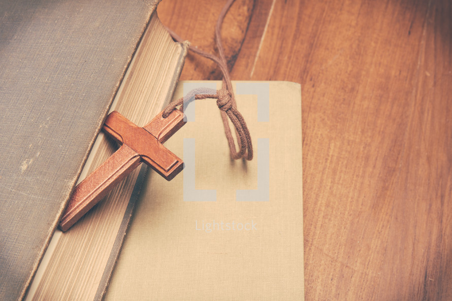 a wooden cross bookmark on a book 