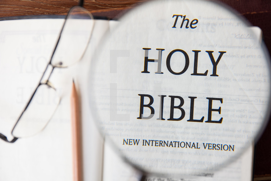 magnifying glass over Bible title page 