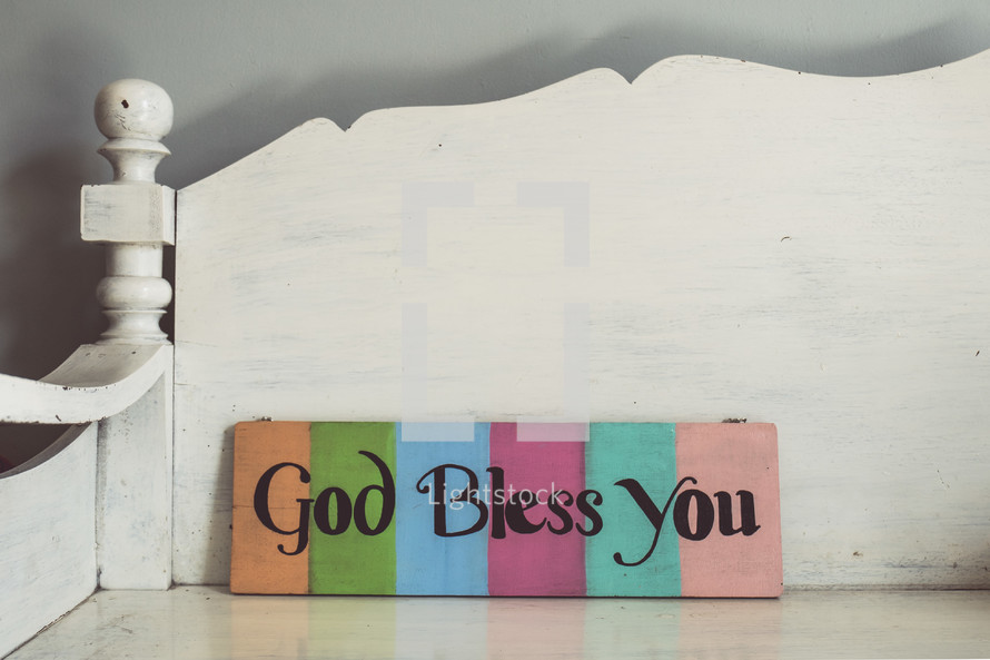 God Bless You sign on a white bench 