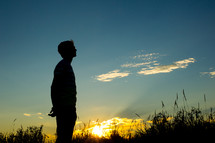 silhouette of a man looking up to God 