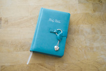 a teal Bible with a locket 