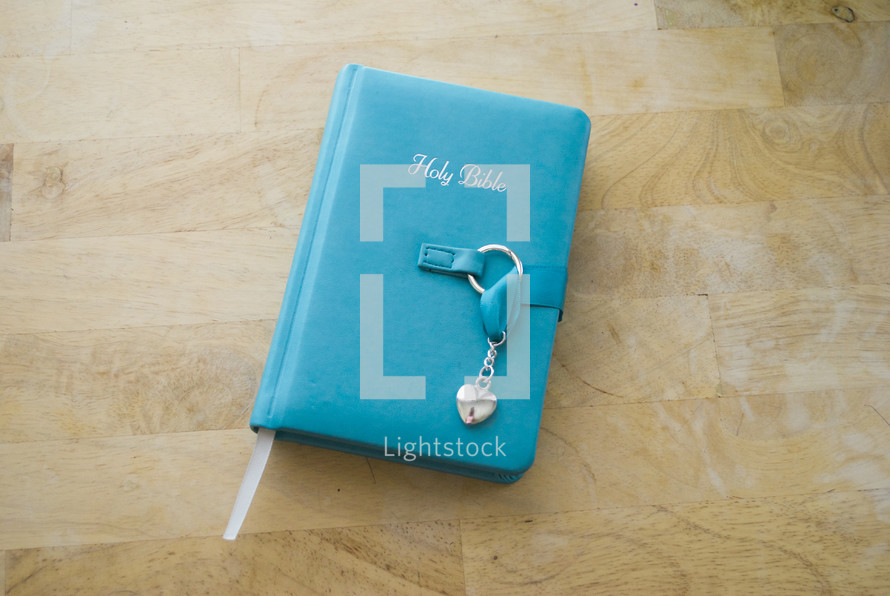 a teal Bible with a locket 