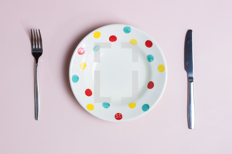 Diet concept with empty plate, fork and knife over the pink background. 