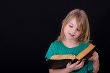 A girl child reading a Bible 