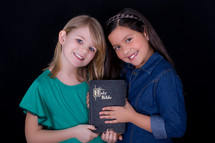Little girls holding a Bible 