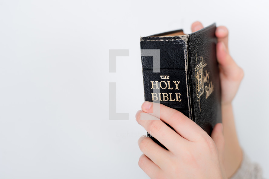 Child's hands holding the Bible.