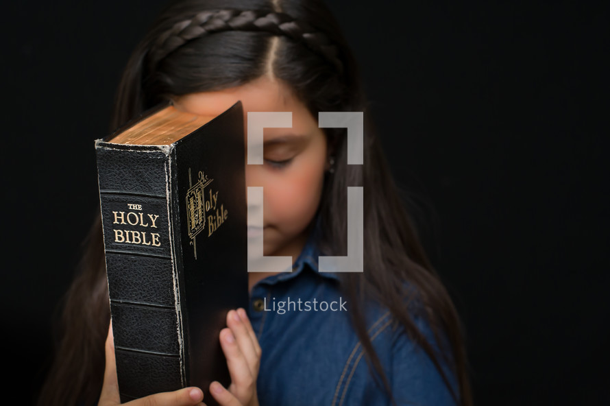 A young girl holding a Bible 