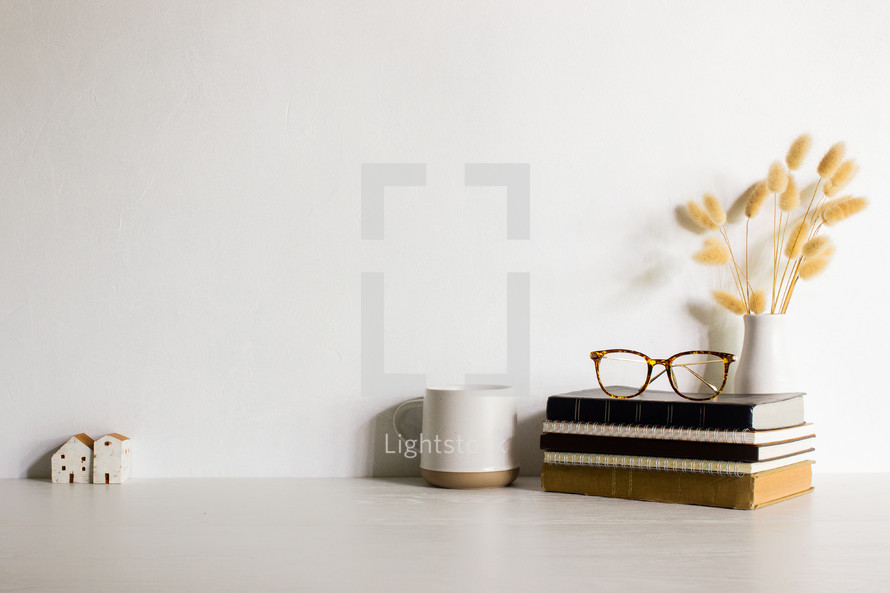 Minimal working items with mini houses, coffee cup, books and flowers. 