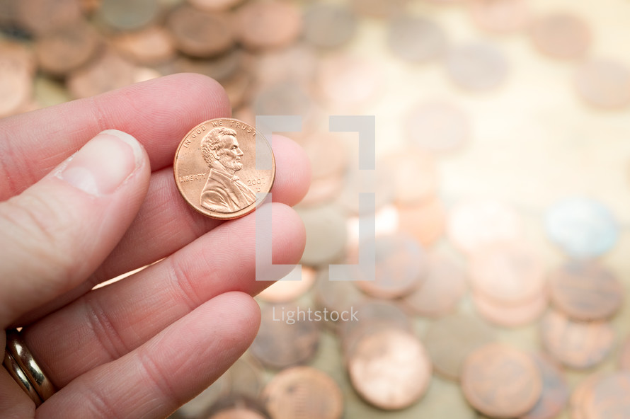 hand holding a penny