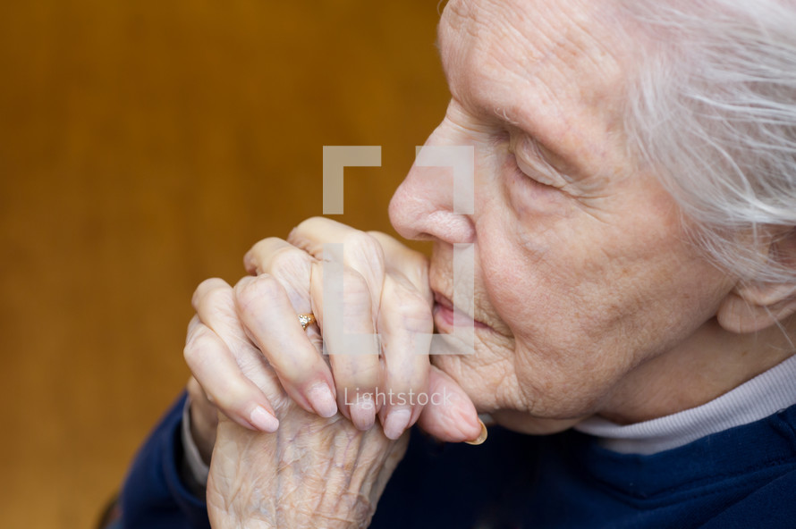 elderly woman with praying hands
