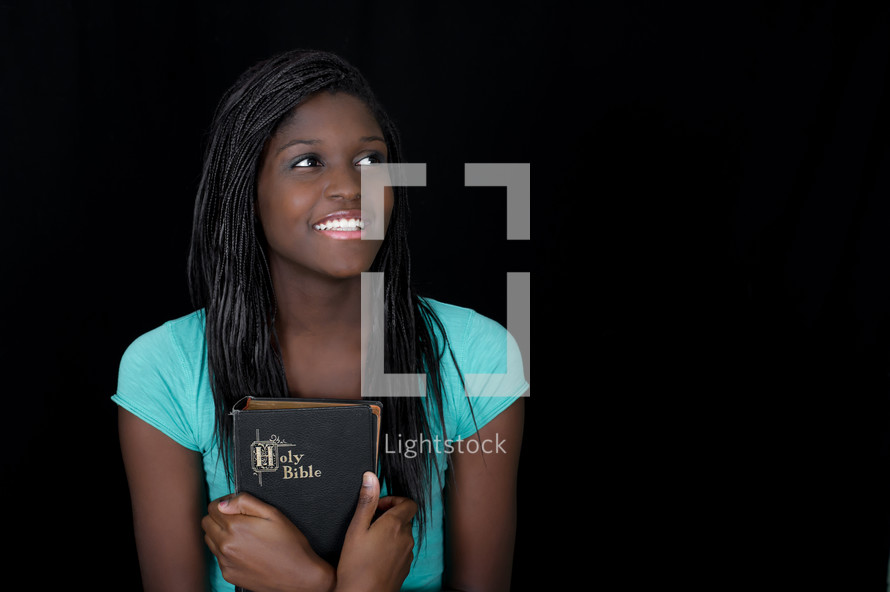 teen girl holding a Bible close to her heart
