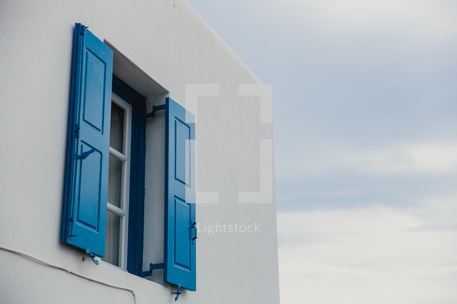 blue shutters on a white house in Greece 