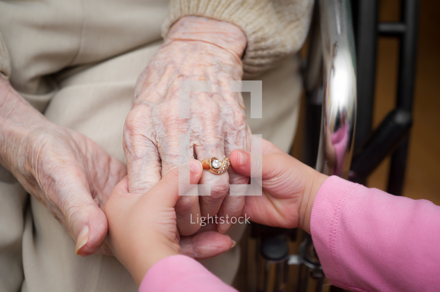Child's hands holding a grandmother's hands.