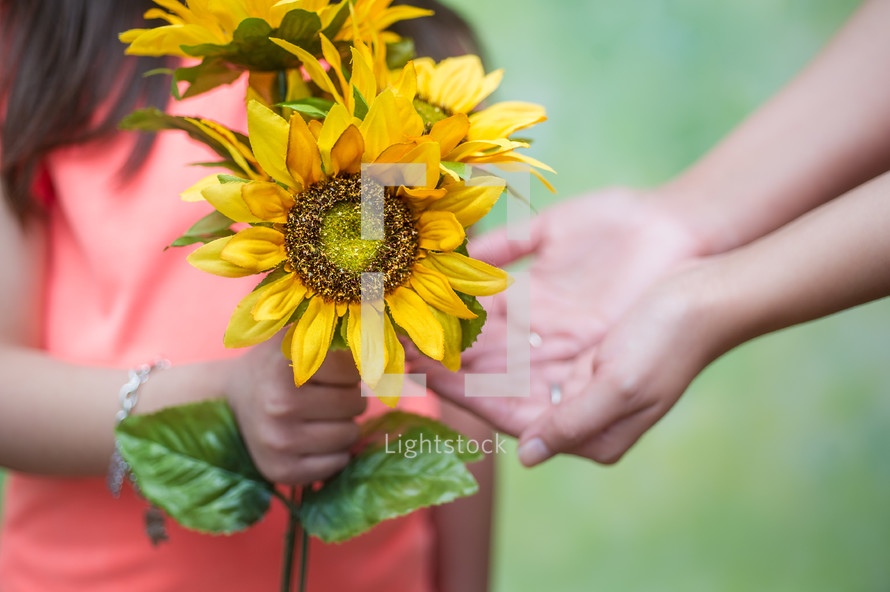 girl handing her mother flowers