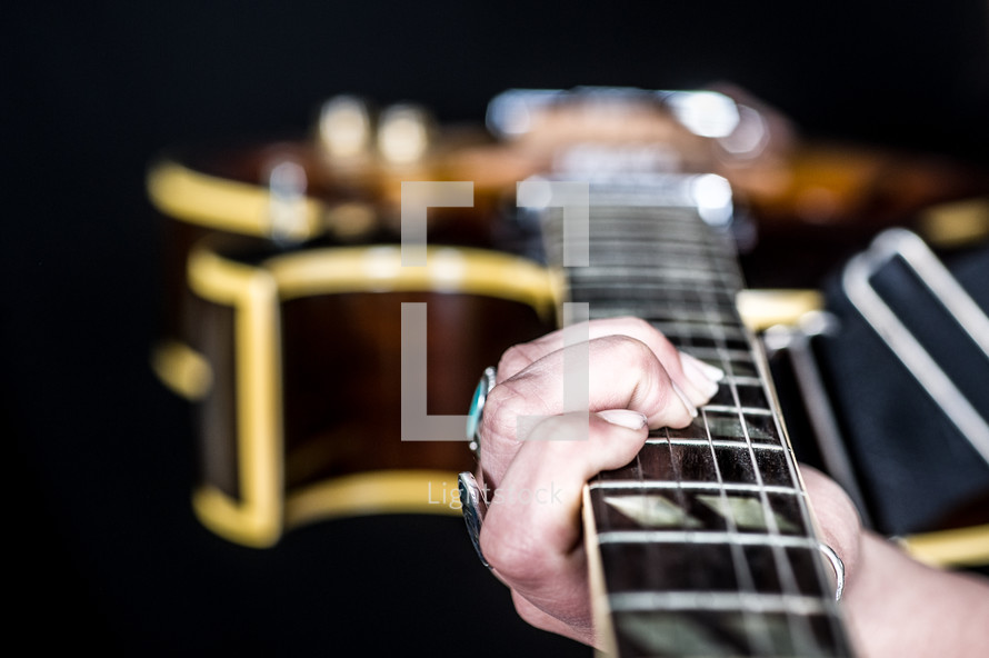 Hands holding a guitar.