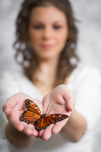 a woman holding a butterfly in her hands
