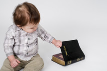 baby boy opening a Bible 