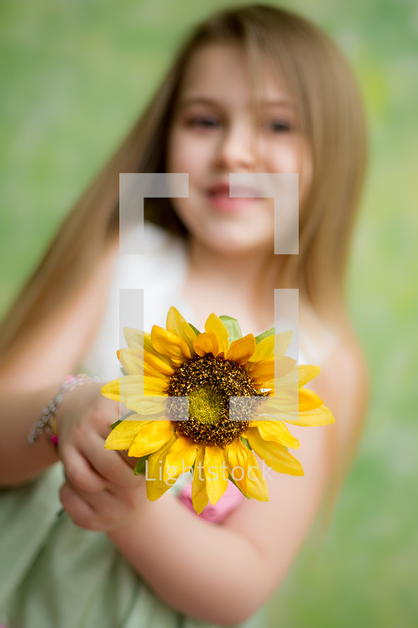 little girl holding a sunflower
