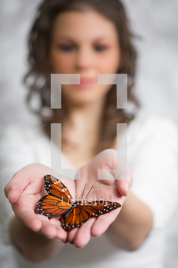 a woman holding a butterfly in her hands