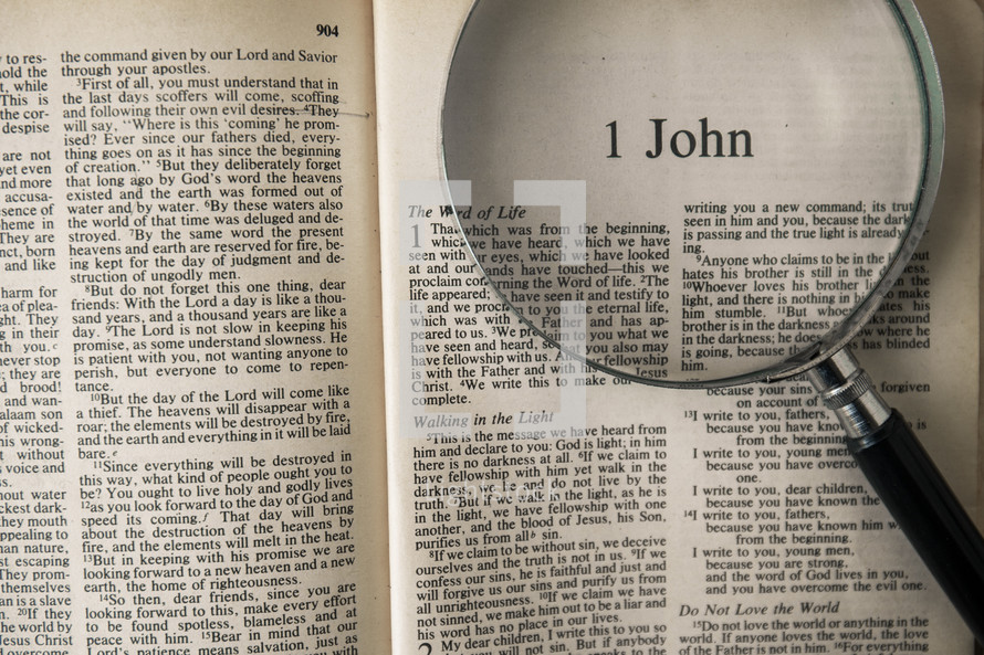 magnifying glass over Bible - 1 John 