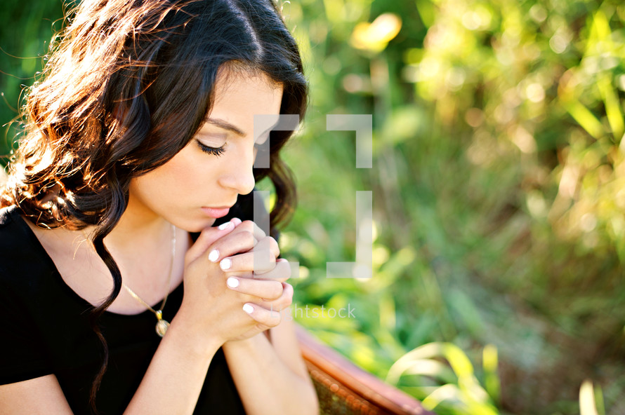 Latino woman with praying hands 