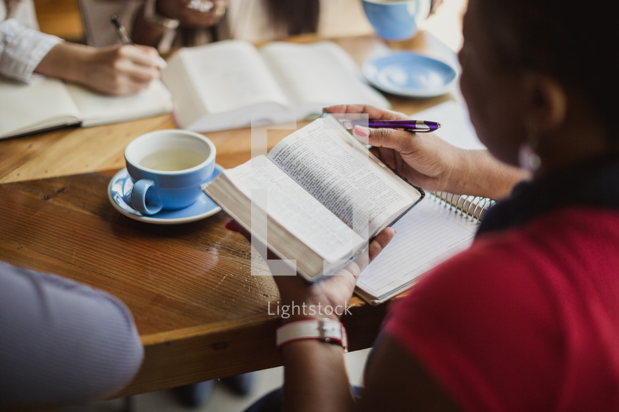women reading Bibles and taking notes at a Bible study 