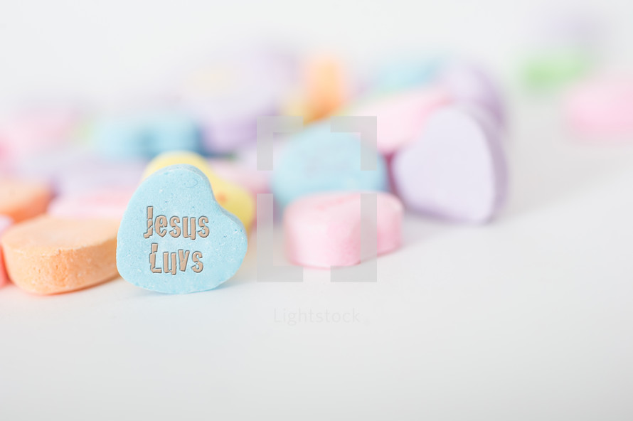 Pile of candy hearts with "Jesus Luvs."