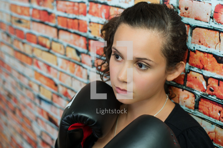female boxer against a brick wall