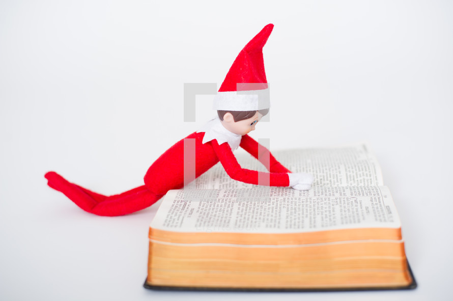 elf on a shelf reading a Bible 