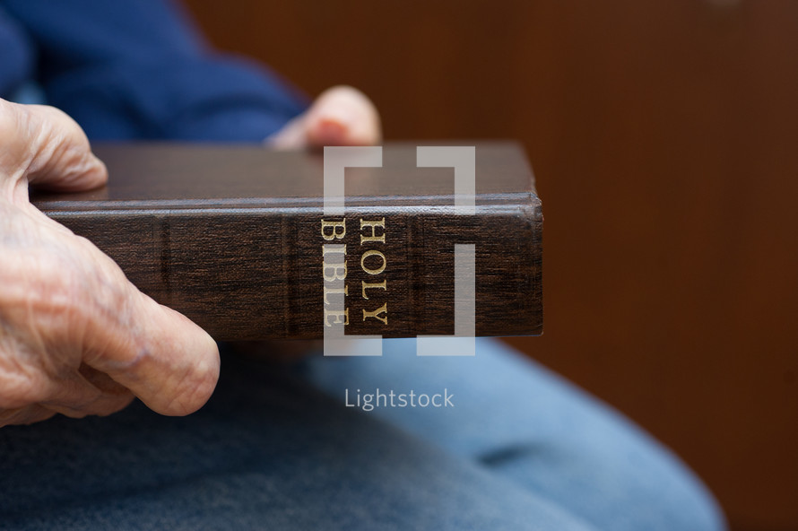 elderly woman holding a Bible 