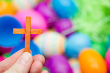 small wooden cross and plastic Easter Eggs