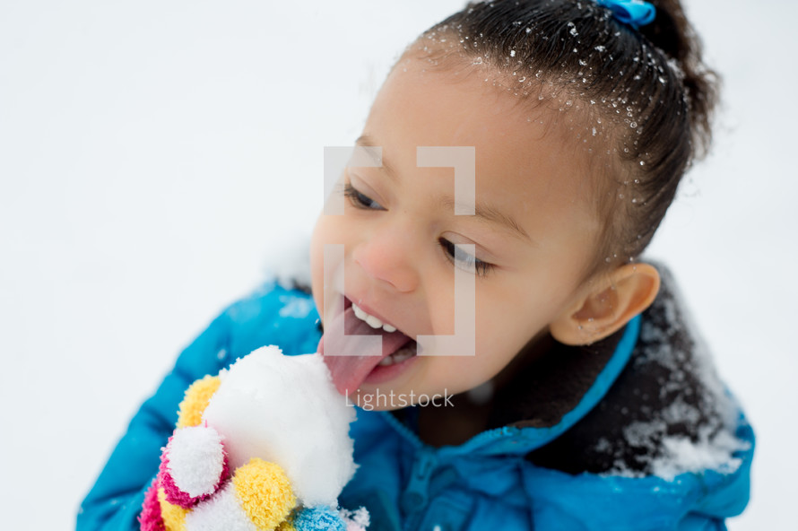 girl child licking a snowball