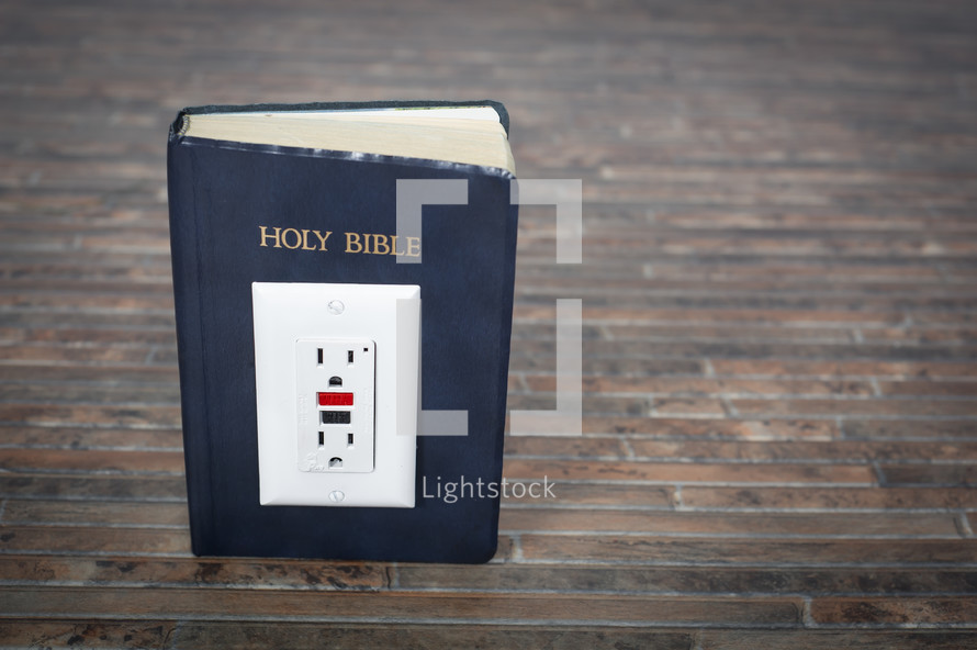 Electrical outlet on the Holy Bible.