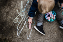toddler boy coloring with sidewalk chalk 