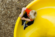 toddler boy on a slide 